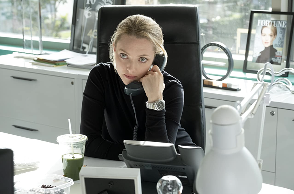 Amanda Seyfried in The Dropout sitting at desk on the phone